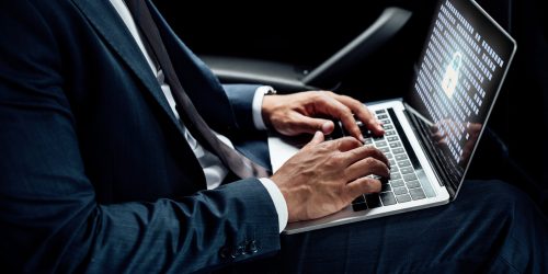 partial view of african american businessman using laptop with gdpr illustration in car